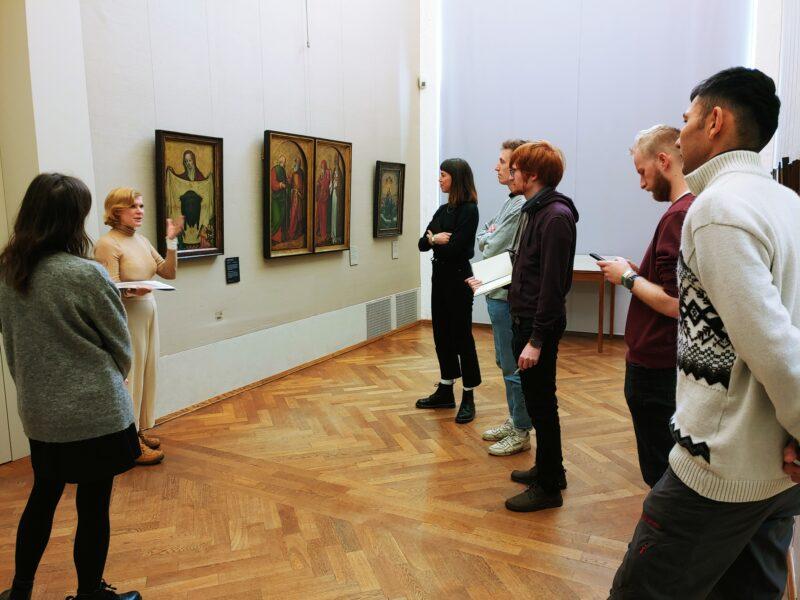 Jasmijn Visser on tour with some doctoral students, standing in front of paintings in the Alte Pinakothek
