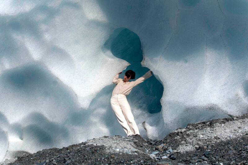 Anne-Sophie Balzer stands curled sideways in a recess about 3 metres high in the glacier ice